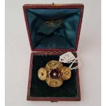A unusual gilt target brooch with central red stone in antique dome topped brooch box