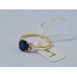 A blue sapphire single stone ring set with two small white sapphires on each shoulder 18ct gold size