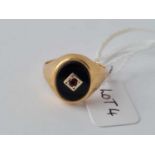 An onyx and garnet mounted signet ring in 9ct - size R - 3.8 g.