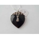 A tortoise shell and silver heart pendant