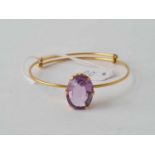 An expanding high carat gold (Egyptian hallmarks) bangle mounted with large oval amethyst - 13 g.
