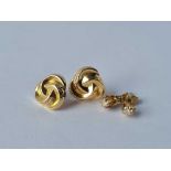 A pair of knot and white stone ear studs 9ct