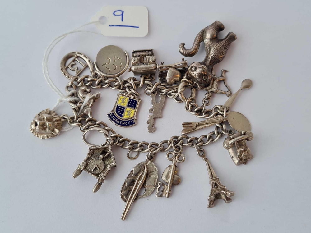 A silver charm bracelet including a large silver cat charm