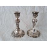 A pair of Victorian candlesticks, decorated with foliage and beaded rims, 6" high, London 1886 by