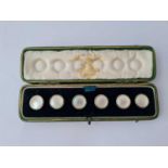 A set of six m.o.p & green enamel buttons in original Child & Child fitted case