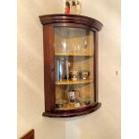 A mahogany bow fronted hanging cabinet with glazed door, 26" high