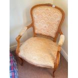 A French style elbow chair with padded arms, carved cabriole legs and pad feet