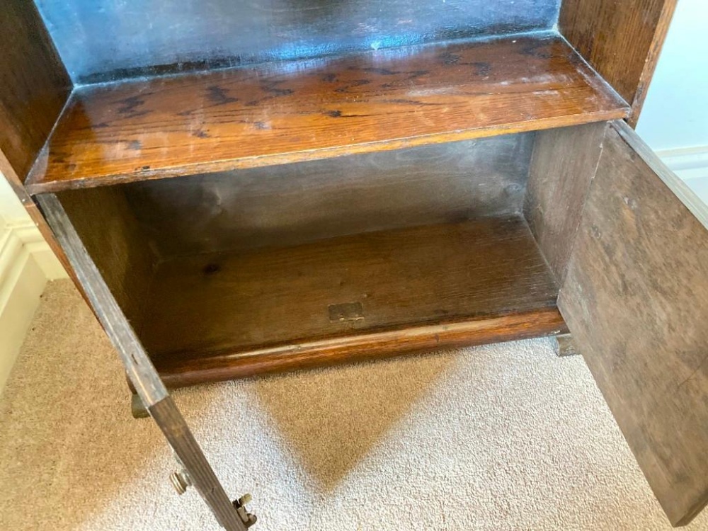 An art deco period small oak bookcase with cupboard to base, 24" wide