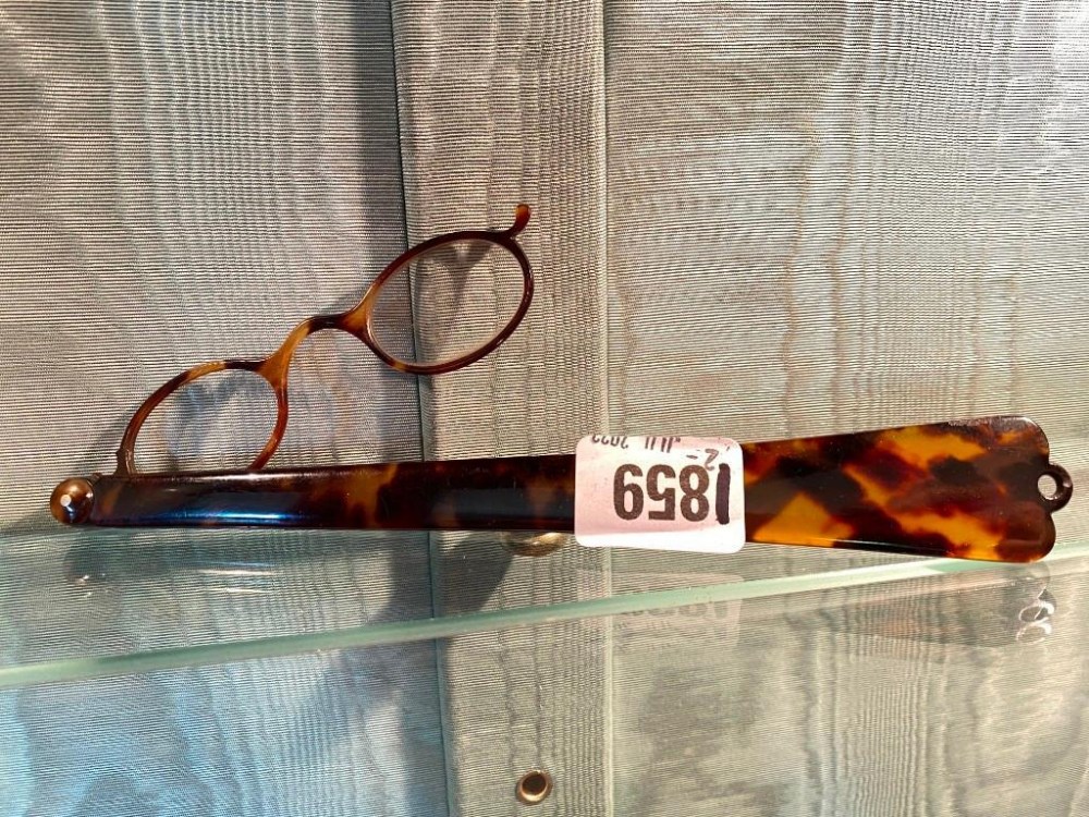 Pair of long handled spectacles, one lense missing