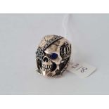 A heavy silver ring in the form of a skull set with sapphires size O