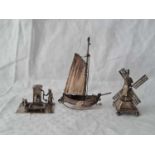 A miniature silver ship, a windmill and a figure at a pump