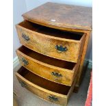 A bow fronted three drawer burr walnut chest with three drawers and bracket feet, 22" wide