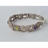 A attractive silver bracelet with bows and swag design set with paste amethyst and peridot stones (