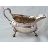 A heavy George II sauce boat on three cabriole legs with pad feet, 8” over handle, London 1756 by