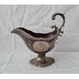 A good early George III sauce boat of rococo design, gadrooned rims and leaf capped handle, 7” long,