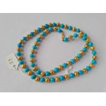 A VICTORIAN GOLD BEAD NECKLACE INTERSPACED WITH BLUE STONE BEADS, 15ct, 21 g. 21” long