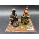 A painted metal ink stand of Turkish man by table