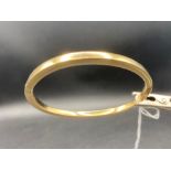 A plain hinged 9ct bangle 9.6g