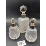 Three mounted scent bottles with silver mounts and glass bodies
