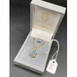 A boxed gold chain and blue stone flower pendant 9ct