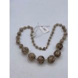 A graduated silver filagree bead necklace