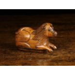 A 19th Century Treen Snuff Box, carved in the form of a recumbent lion with glass inset eyes,