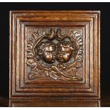 An 17th Century Flemish Oak Panel relief carved with a pair of cherub heads encircled by a