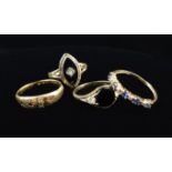 Four Rings: A 14 carat gold ring with a navette shaped black stone centred by a diamond in an