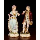 A Pair of Continental Porcelain Figures of Lady & Beau in elaborately decorated costumes,