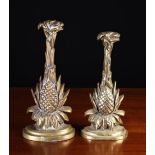 Two Brass Door Stops, each cast with a pineapples issuing a spout of foliage,