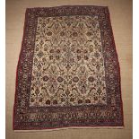 A Persian Style Carpet woven with floral motifs on an ivory ground within a decorative banded