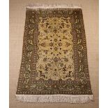 A Persian Style Silk Rug woven with palmettes and flowers on interlaced scrolling stems to a golden