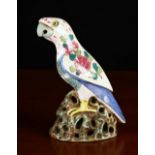 A Porcelain Parrot decorated in polychrome enamels with sprays of peonies to it's wings,
