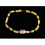A Vintage Hattie Carnegie Lucite Yellow and Black striped "Humbug" Bead Necklace.