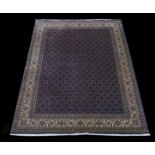 An Indo Mahi Tabriz Wool Carpet with all over trellis design of small flower heads on a dark blue