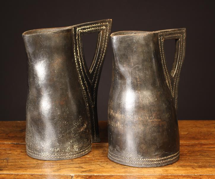 Two Early 19th Century Leather Black Jacks with cut out angular handles and double stitched seams.