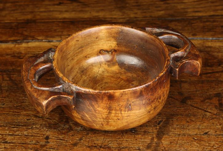 A 19th Century Fruitwood Quaich. The turned bowl with raised foot and pierced lug handles, 1¾" (4.