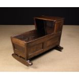 An Early 18th Century Joined Oak Cradle having splayed twin panel sides and a flat topped hood,