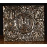 A 16th Century Boldly Carved Panel centred by a face mask in a moulded roundel amidst opulent