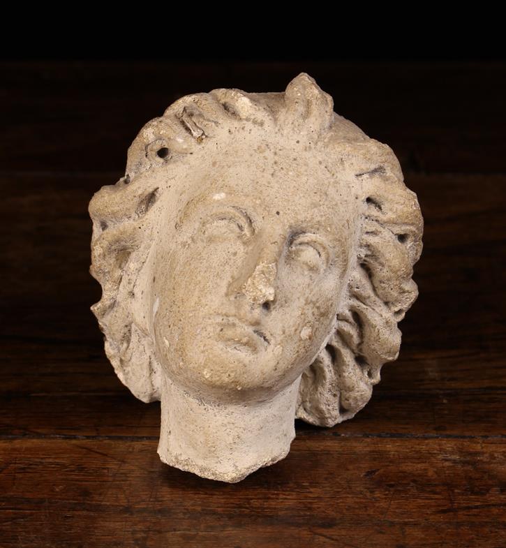 A 17th Century Stone Fragment Carving of a Saints head depicted with curly windswept hair, 4½" (11.