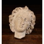 A 17th Century Stone Fragment Carving of a Saints head depicted with curly windswept hair, 4½" (11.