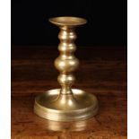 A Heavy Gauge Brass Candlestick in the 17th/18th century style with a multi knopped stem on a round