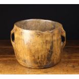 An Irish Rustic Dug-out Treen Butter Tub with pierced lug handles either side of the cylindrical