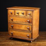 A 19th Century Fruitwood Apprentice Piece: A miniature chest of drawers having three small upper