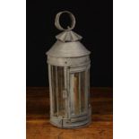 A 19th Century Tin Candle Lantern with glazed hexagonal sides below a conical top with crimped vent