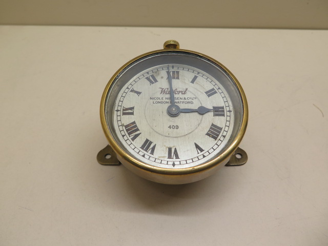Watford: An early car clock of brass construction with footboard angled mount, the 9cm diameter