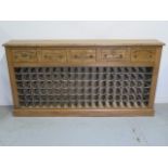 A pine 108 bottle wine rack with four wine box fronted drawers, made by a local craftsman to a