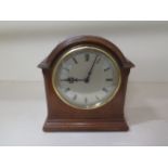 A small walnut mantle clock, 18cm tall, in working order