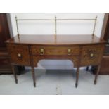 A 19th century inlaid mahogany bowfronted sideboard with two drawers and a cupboard having a brass