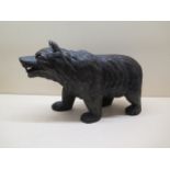A well carved Black Forest bear with glass eyes, 21cm tall x 34cm long, in good condition